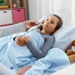“child with fever being checked with a thermometer – fever in children”